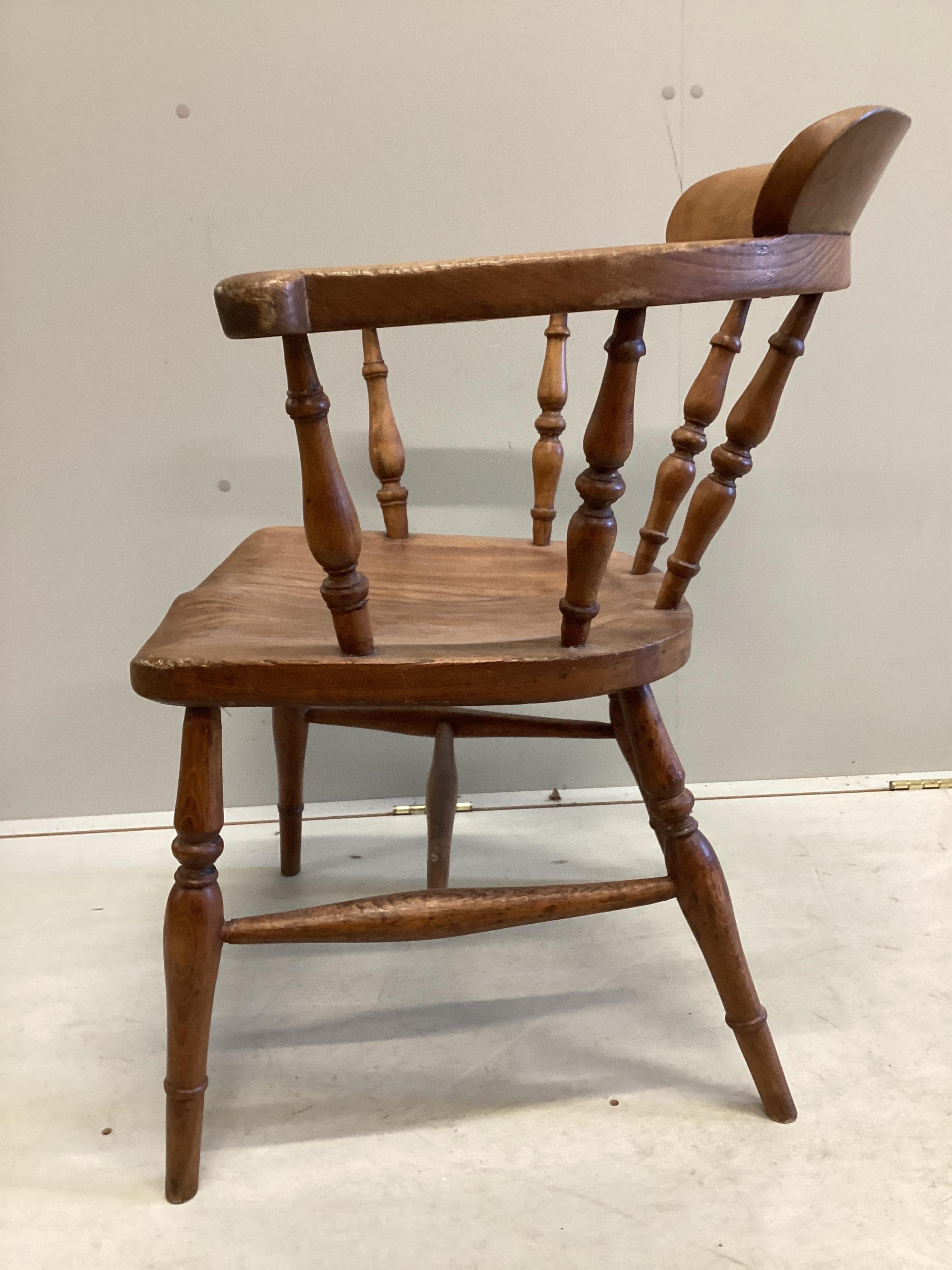 A Victorian elm and beech smoker's bow elbow chair on slender turned baluster legs with H stretcher, width 62cm, depth 45cm, height 78cm. Condition - good, timber slightly faded.